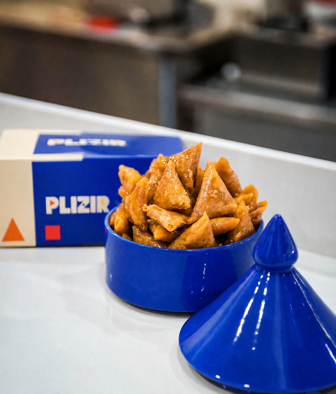 Triangles PLIZIR servis dans un tajine bleu avec la box PLIZIR